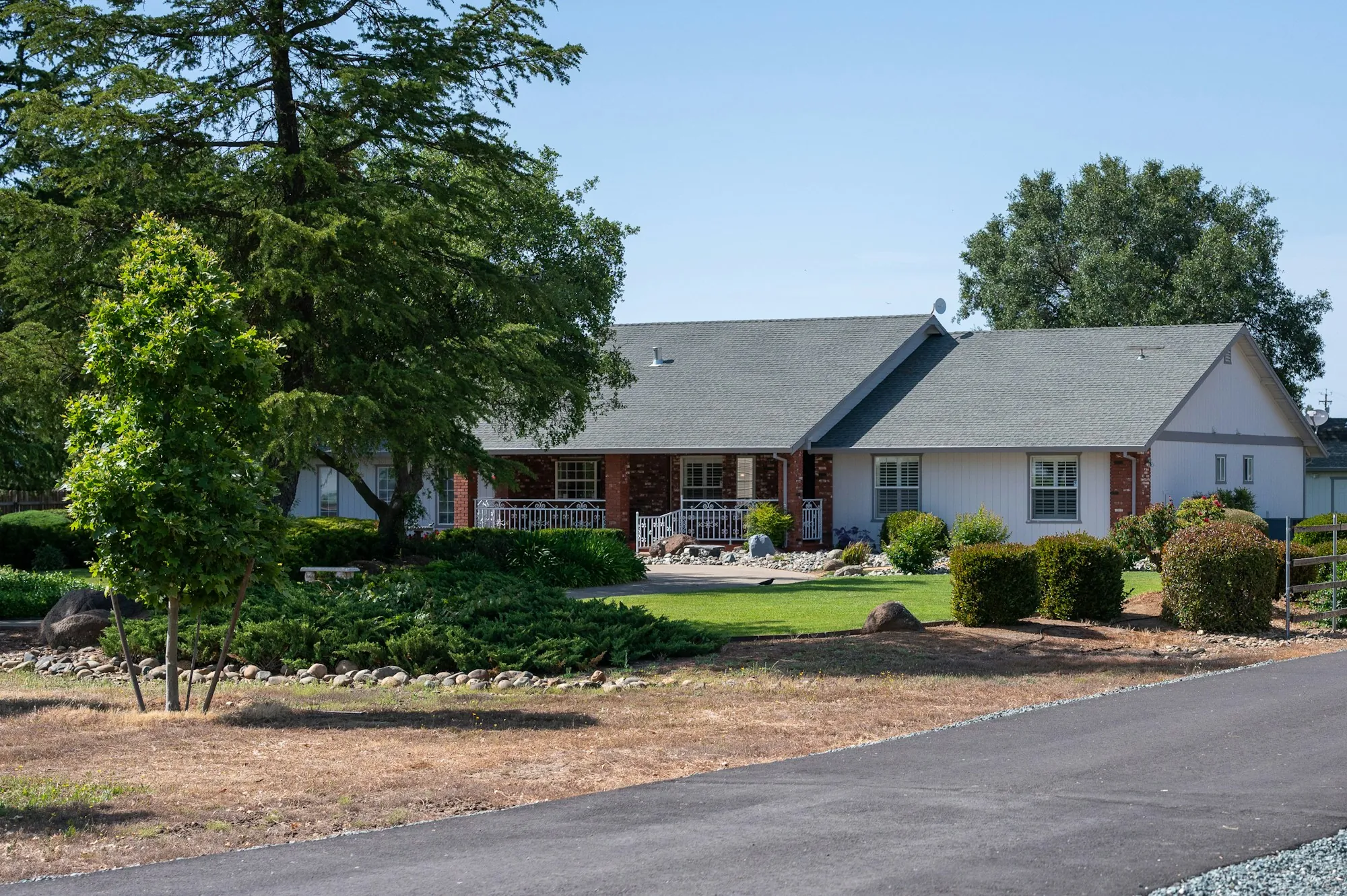 Single-story ranch house surrounded by mature trees